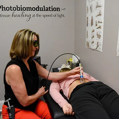 Chiropractor Pittsboro NC Jenni Sherwood Using Laser Device On Patient